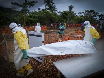 MSF staff hand over a body to an IFRC burial team at MSF’s Case Management Centre in Kailahun, Sierra Leone. ©Fabio Basone, MSF