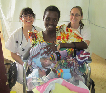 Former UBC Citizens for Global Midwifery Program participants Natalie Amran and Quinn Metcalfe celebrate with a new mother of twins in Uganda in 2012.