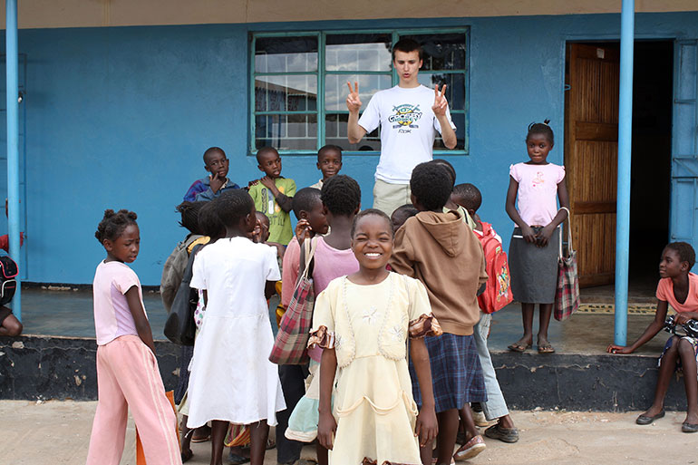Tim Krupa plays with children orphaned by HIV and tuberculosis in the impoverished Chazanga compound in Lusaka, Zambia. Credit: Alexa Geddes